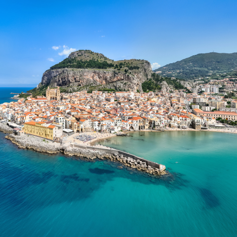 Cefalù City Aerial Drone Point of View Panorama over the turquoise Mediterranean sea of north Sicily's tyrrhenian coast