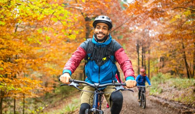 Cyclist biking through the woods in the fall