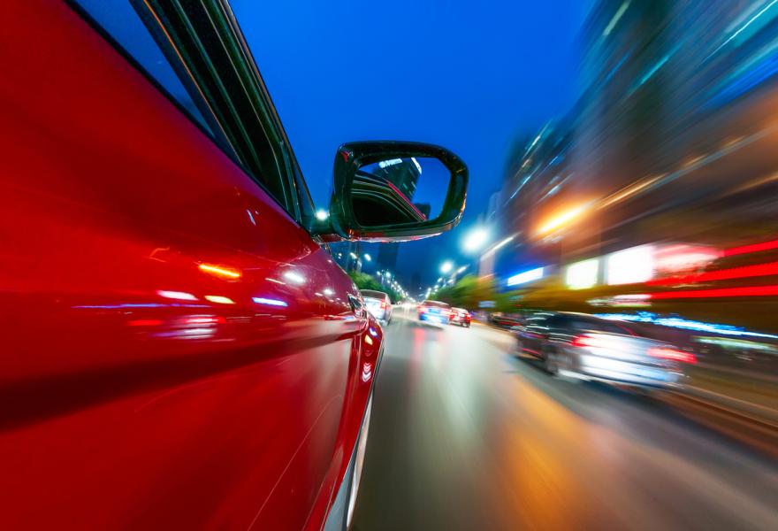 A car driving on a motorway at high speeds, overtaking other cars